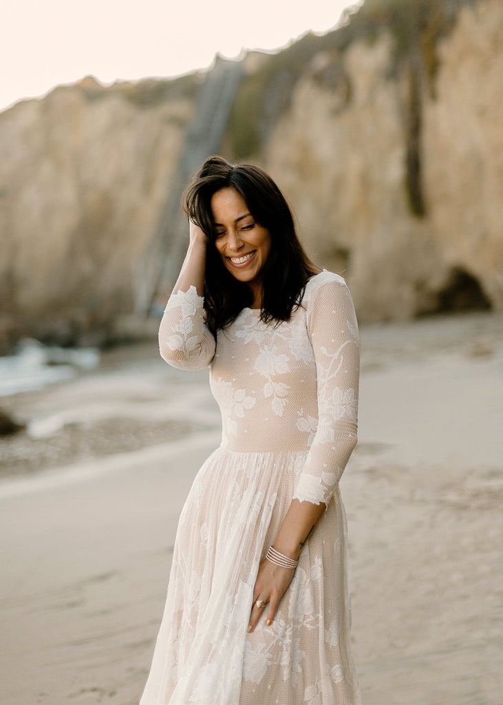 Smiling bride on beach wearing the Ari wedding dress