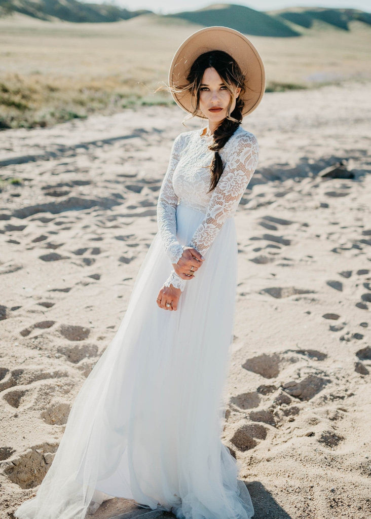 Bride in hat on beach wearing Zoey 2.0 boho wedding dress
