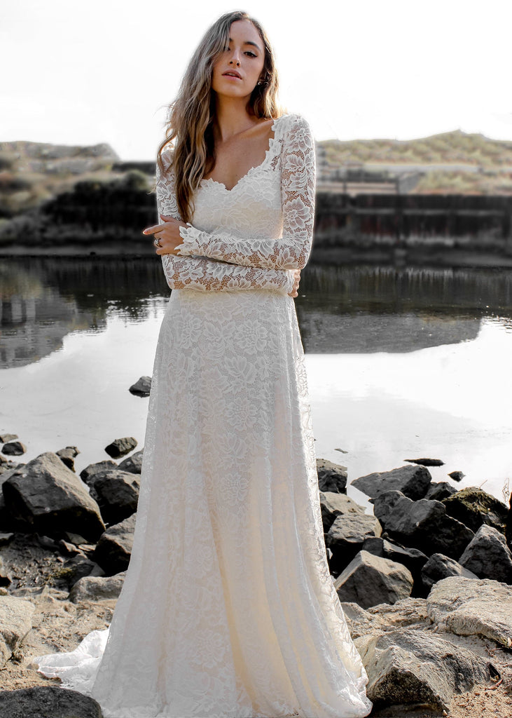 Bride wearing Indigo Dress, posing in front of rocks and very still pond