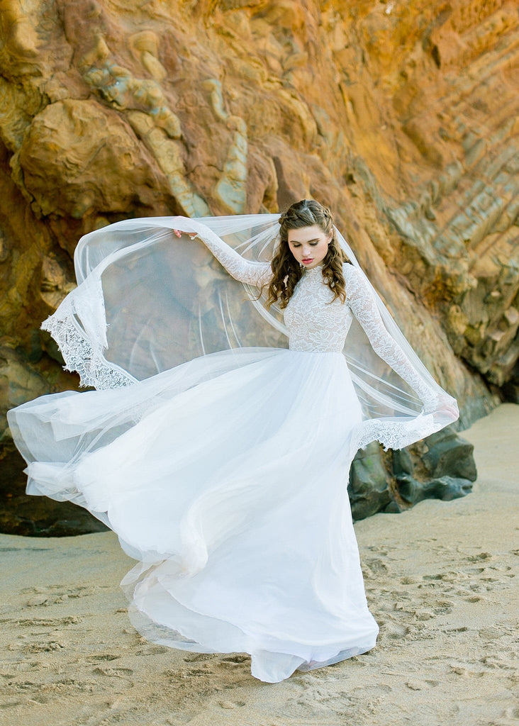 Bride on beach wearing Zoey 2.0 long sleeve bohemian style wedding dress
