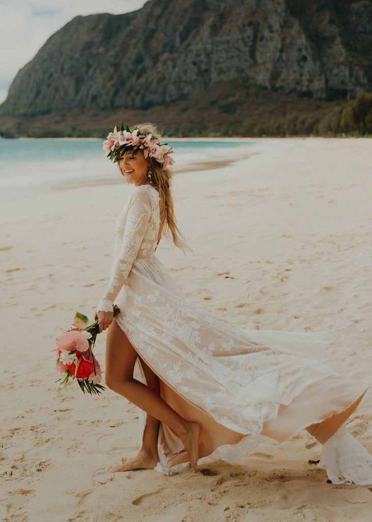 Bride on beach wearing flowe crown and long sleeve Ari wedding dress