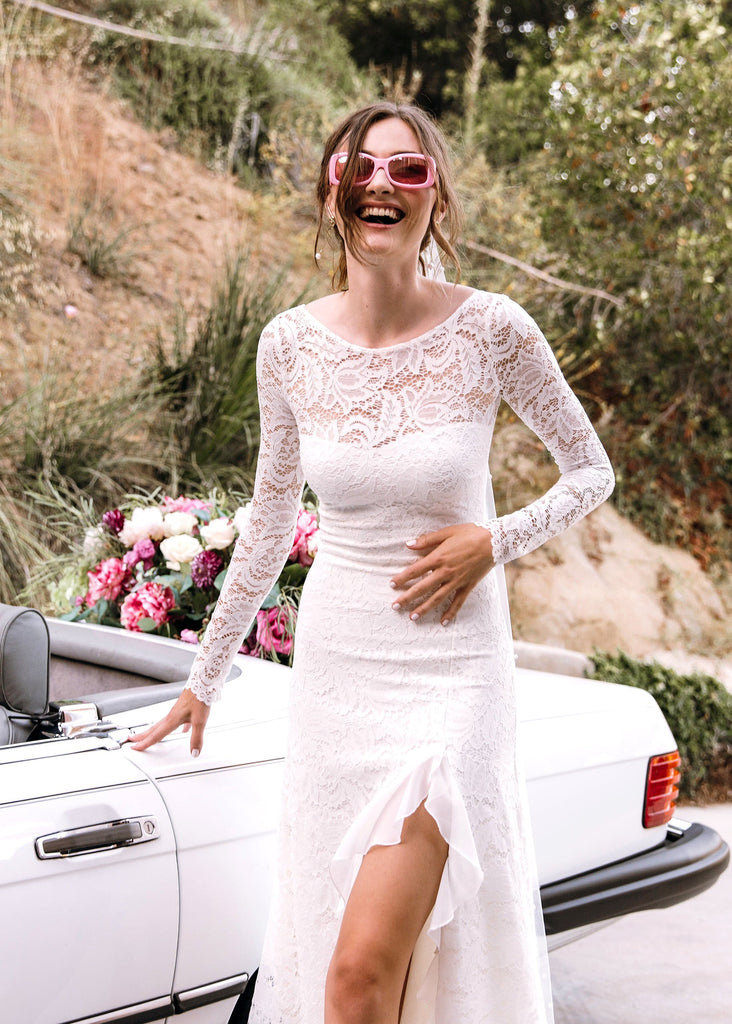 Laughing bride in front of white convertible in pink sunglasses and Sasha Dress